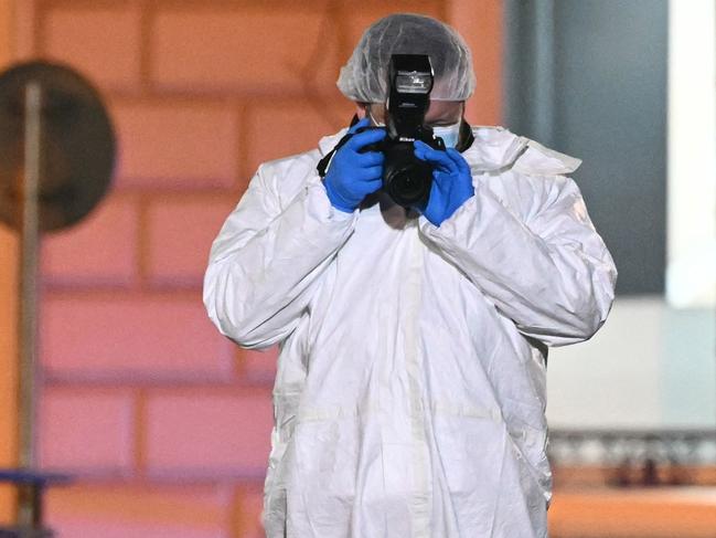 A French forensic police officer takes pictures as he works on the site of the knife attack. Picture: AFP