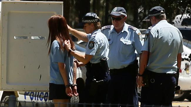 The 15-year-old girl is led from the grounds of the school. Picture: Justin Sanson