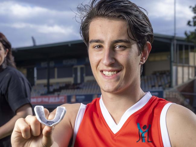 Exclusive story on a new smart mouthguard that can warn parents if their kids had a knock in a sporting game that puts them at risk of concussion. 18-year-old Nick Perizzolo from Northern Bullants with mother Susy and club president Whitlam Malkoun.Picture by Wayne Taylor 7th March 2023