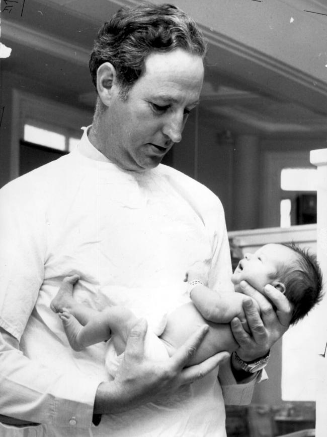 Dr William McBride, who delivered the author of this article, holding another baby. A Sydney doctor, he made the link between the drug thalidomide and deformities in babies.