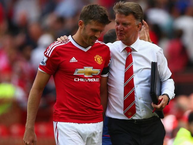 Michael Carrick of Manchester United walks with Louis van Gaal.