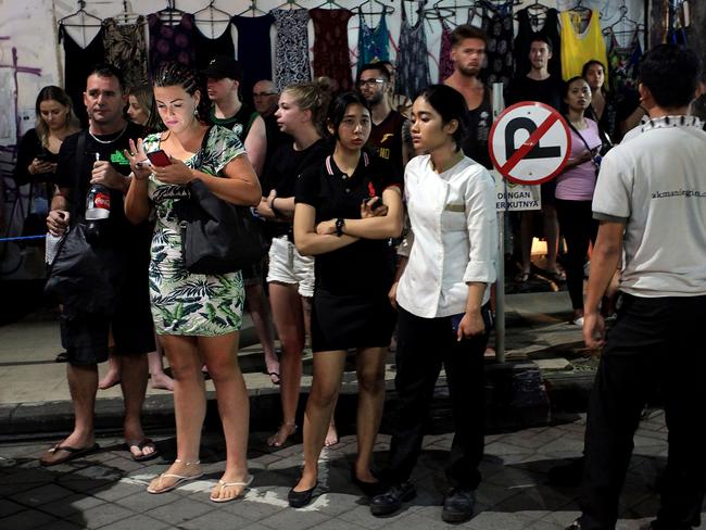 Tourists and hotel staff stand on the street after being evacuated from their hotels. Picture: AFP