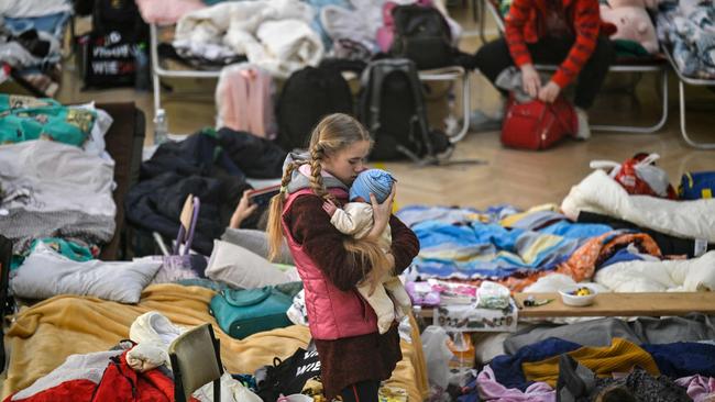 A girl holds her sibling in a temporary shelter for Ukrainian refugees in a school in Przemysl, near the Ukrainian-Polish border. The number of refugees fleeing Ukraine is now nearly 2.7 million, the UN said. Picture: Louisa Gouliamaki / AFP