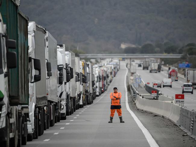 A driver looks towards protesters as they check the contents inside trucks at the A9 highway exit linking Spain and France to block the tractors and farmers as part of nationwide protests called by several farmers' unions over pay, tax and regulations, in Boulou, south of Perpignan, on February 1, 2024. French farmers protesting over pay, tax and regulation kept up their roadblocks on February 1, 2024 as eyes turned to Brussels in hope of more European Union concessions. Seven blockades remained in place on motorways around Paris late January 31, throttling access to the capital (Photo by Ed JONES / AFP)