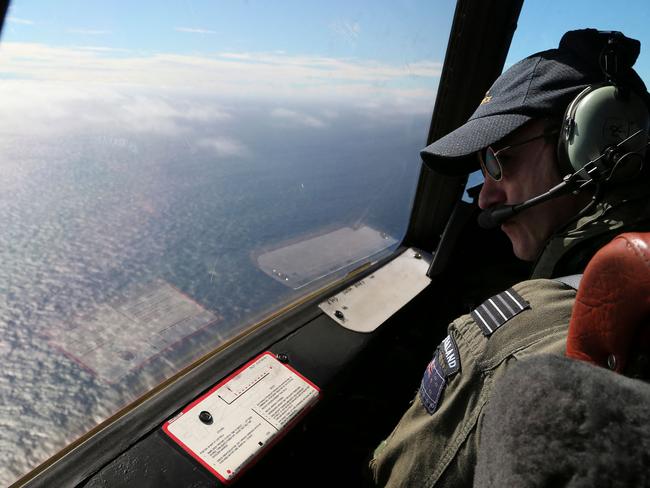 Royal New Zealand Air Force P3 Orion captain Wing Commander Rob Shearer looks out of the window of his aircraft while searching for MH370. Picture: AFP