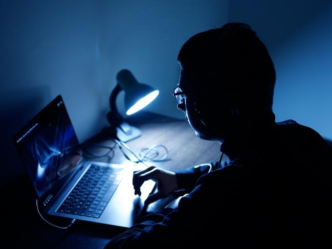 A young person in a dark atmosphere at his computer. Photo: iStock