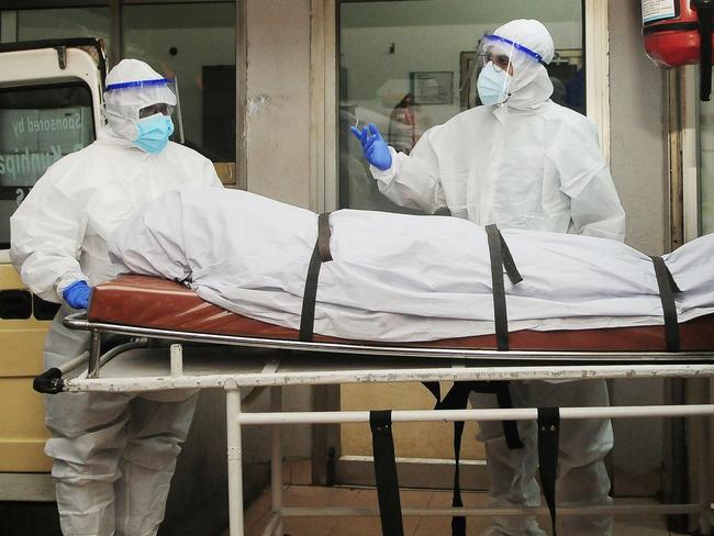 In this photograph taken on September 12, 2023, health workers wearing protective gear shift the body of a person who died of a Nipah virus infection at a private hospital in Kozikode, in India's Kerala state. India has curbed public gatherings and shut some schools in the southern state of Kerala after two people died of Nipah, a virus from bats or pigs that causes deadly fever, officials said on September 14. (Photo by AFP)