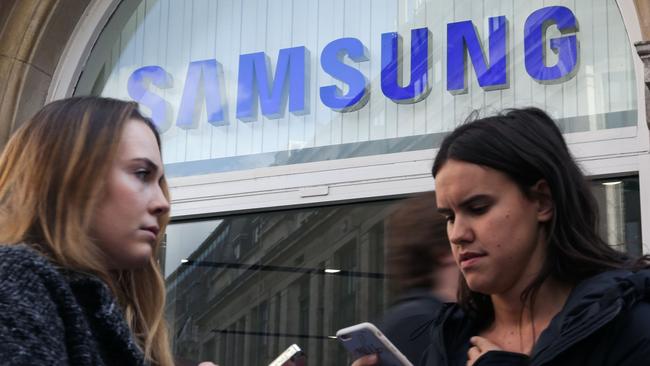 Woman use their smartphones near a Samsung store. Samsung suspended all production of its Galaxy Note 7 smartphone, halted sales worldwide and told customers to stop using the device. Picture: AFP PHOTO / Daniel Leal-Olivas