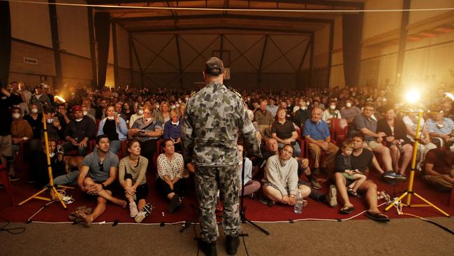 Commander Scott Houlihan of HMAS Choules talks to the hundreds gathered at the Mallacoota Town Hall meeting about evacuation on the ship. Picture: David Caird