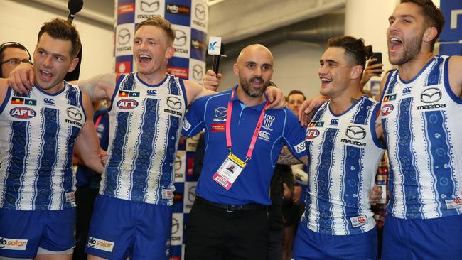 Rhyce Shaw joins in with the players for the North Melbourne song in the rooms after the game. Picture: Michael Klein