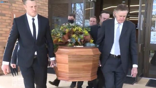 Travis Tuck and Michael Tuck help carry the casket at Shane Tuck’s funeral.