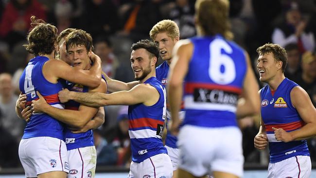 Josh Dunkley (third from left) reacts after kicking a goal against Carlton.