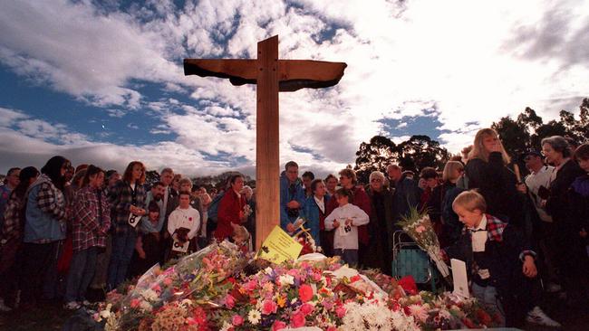 Mourners at a memorial service after a simple wooden cross was erected at the site of the Port Arthur killings