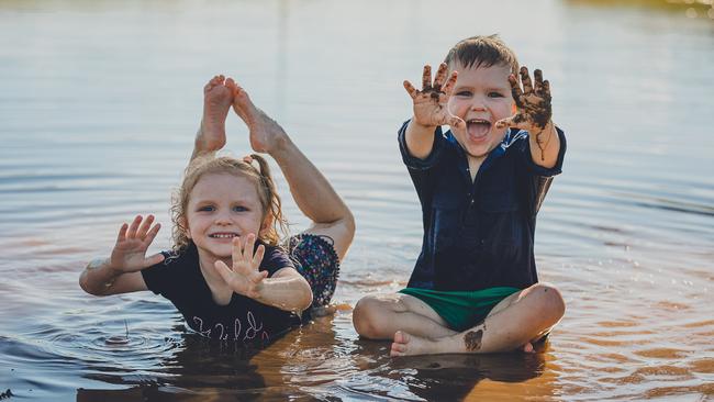 Bonnie and Dusty Ricketts, playing in the rain at Lewah about 20km North of Roma. Picture: Katrina Ayers