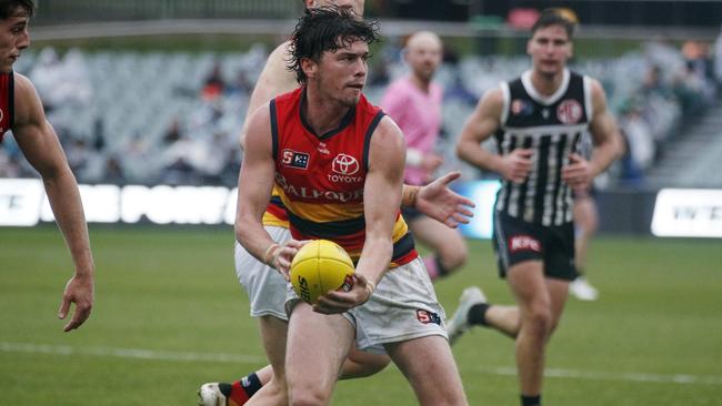 Ned McHenry handballs for Adelaide. Picture: Peter Argent