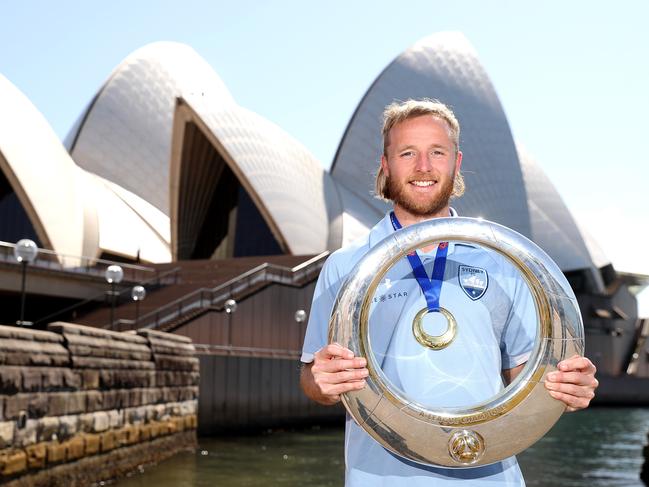 SYDNEY, AUSTRALIA - AUGUST 31:  Rhyan Grant poses with the A-League Trophy during an A-League media opportunity after Sydney FC won last night's Grand Final, at Sydney Opera House on August 31, 2020 in Sydney, Australia. (Photo by Mark Kolbe/Getty Images)
