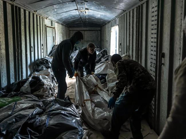 A Ukrainian civil-military co-operation team (CIMIC) move the bodies of Russian soldiers from a refrigerated rail car in Kharkiv, Ukraine. Picture: Getty Images