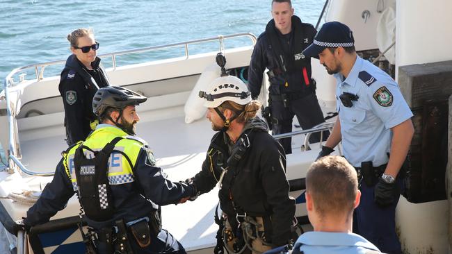 Police detained three protesters after lowering them onto police boats below the bridge. Picture: Richard Dobson