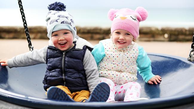 All rugged up and as cute as can be … two-year-olds George Smith and Elyse Crabb enjoy a swing in Manly on Tuesday. Picture: Tim Hunter