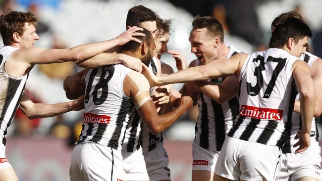 Magpies players celebrate a Travis Varcoe (centre) goal. Picture: AAP