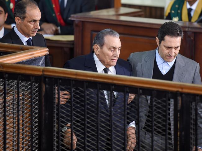 Former Egyptian president Hosni Mubarak (C), who was ousted following a popular uprisal in 2011, being escorted by his two sons Alaa (R) and Gamal (L) as he testifies during a session in the retrial of members of the now-banned Muslim Brotherhood over charges of plotting jailbreaks and attacks on police during the 2011 uprising, at a make-shift courthouse in southern Cairo. Picture: AFP