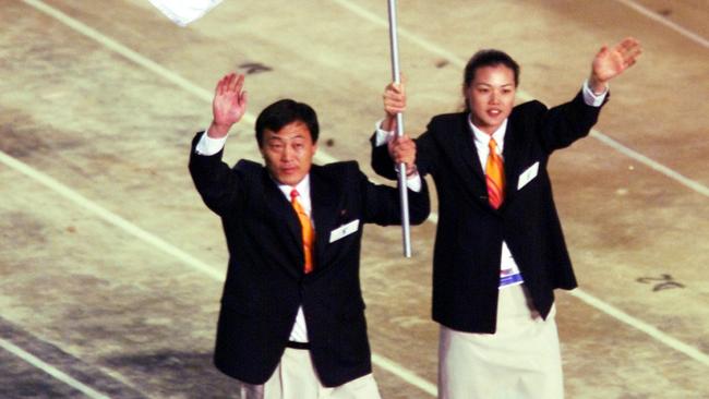 North Korean judo coach Pak Jung Chul (left) and Chung Eun-sun, a South Korean basketball player, carry a flag representing a united Korea into the Olympic Stadium during the Opening Ceremony of the Sydney Olympic Games on September 15, 2000.