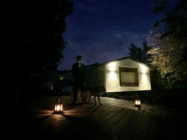 Lachlan and dogs Ellie and Zee lighting up the dawn in their driveway at Hahndorf. Photo: Tricia Watkinson/Sunday Mail.