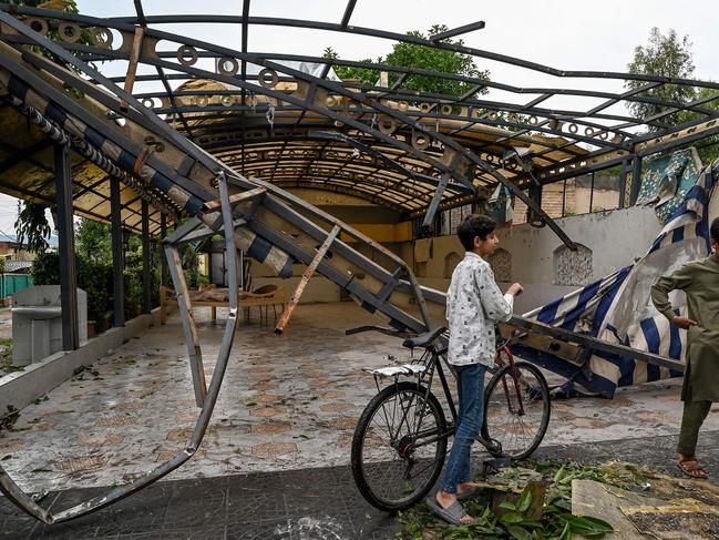 Youths gather in front of the wreckage of a restaurant's shade outside the Rawalpindi cricket stadium after an alleged drone was shot down. Picture: AFP