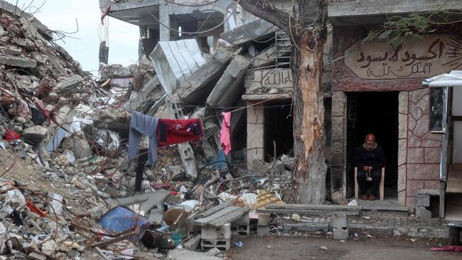 A Palestinian man sits in the doorway of a war-damaged building during the Muslim holy fasting month of Ramadan, in the Nuseirat refugee camp in the central Gaza Strip.