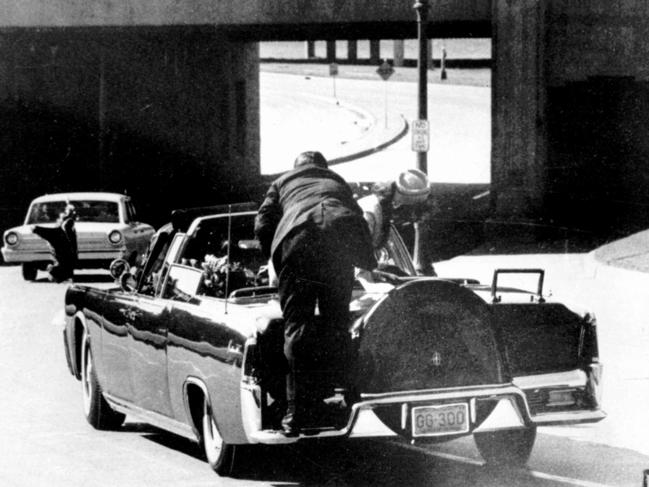 Jacqueline Kennedy and a secret service agent climbing onto presidential car in reaction to the assassination of US President John F Kennedy