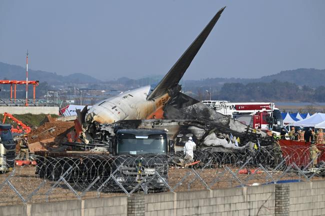 Rescue personnel work near the wreckage of a Jeju Air plane after it crashed at South Korea's Muan International Airport, killing 179 people on board