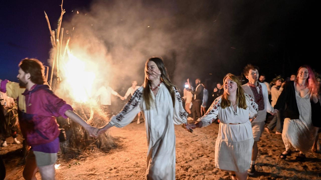 People dance around the fire during the Kupala night celebrations near Yagidne village, Chernihiv region after volunteering to clear destroyed buildings. Picture: AFP