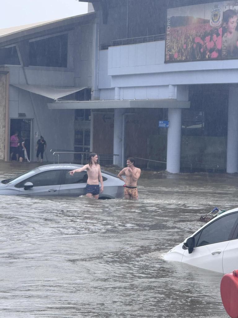 Timmy Rhodes took this image of good Samaritans checking cars in the RSL carpark as flash flooding hit Hervey Bay during the wild weather brought by ex-Tropical Cyclone Alfred.