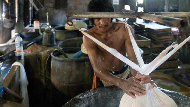 A local man works at a factory producing tofu at Klagen Tropodo village outside Surabaya, Indonesia. Picture by Graham Crouch/The Australian