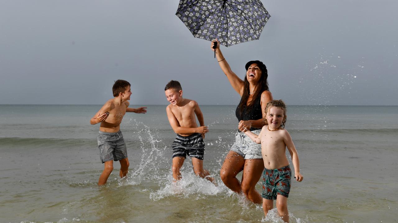 Andrea Lowe has fun in the rain at Henley Beach with her son and his friends, from left, Harley Hudson 11, Max Lowe, 8, and Fletcher Gower 5. Picture: Tricia Watkinson.