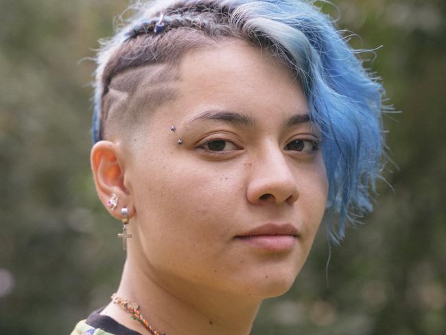 Young cheerful woman with expression of sadness and blue short hair. transgender stock image