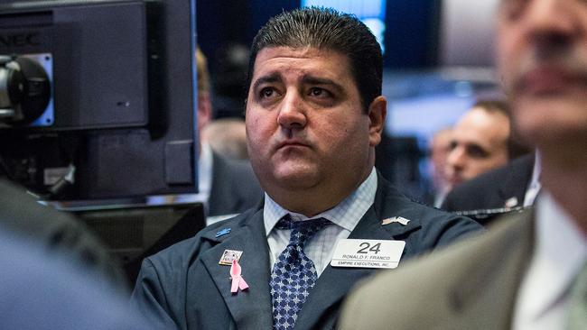 NEW YORK, NY - NOVEMBER 16: Traders on the floor of the New York Stock Exchange participate in a moment of silence in honor of the victims of the terrorist attacks in Paris last week before the opening trading bell on November 16, 2015 in New York City. French and U.S. flags also flew at half mast outside the New York Stock Exchange. Andrew Burton/Getty Images/AFP == FOR NEWSPAPERS, INTERNET, TELCOS & TELEVISION USE ONLY ==