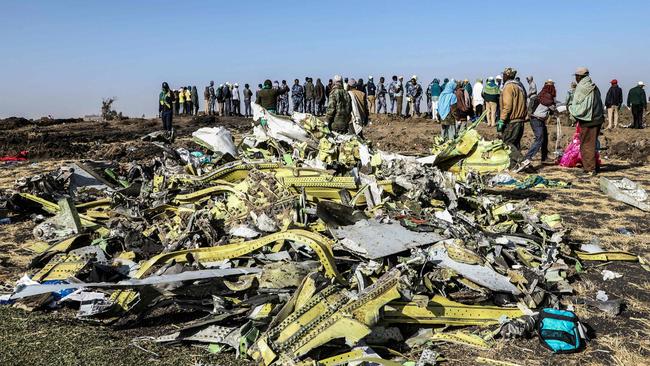 (FILES) In this file photo taken on March 11, 2019, people stand near collected debris at the crash site of Ethiopia Airlines near Bishoftu, a town some 60 kilometres southeast of Addis Ababa, Ethiopia. - A preliminary report from the fatal crash of a Boeing 737 Max in which 157 people died in Ethiopia will be released on April 1, 2019, Ethiopia's foreign ministry said. The Boeing 737 MAX 8 operated by Ethiopian Airlines crashed on March 10, southeast of Addis Ababa. (Photo by Michael TEWELDE / AFP)