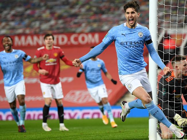 MANCHESTER, ENGLAND - JANUARY 06:  John Stones of Manchester City celebrates after scoring his team's first goal during the Carabao Cup Semi Final match between Manchester United and Manchester City at Old Trafford on January 06, 2021 in Manchester, England. (Photo by Shaun Botterill/Getty Images)
