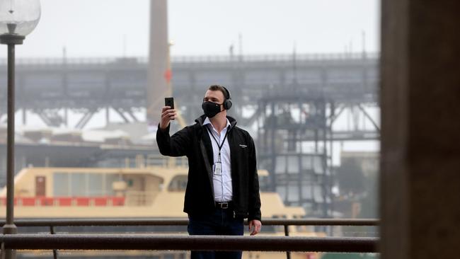 A masked man takes a selfie at Circular Quay in Sydney. Picture: Damian Shaw