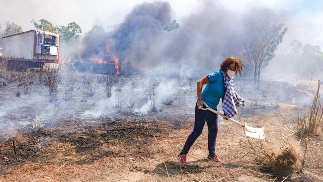 Sarah Winchcombe defends her son’s rental property during a bushfire at Richardson Rd, Humpty Doo (above and below). Pictures: Glenn Campbell