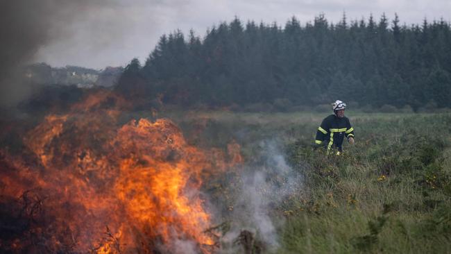 Firefighters spray water on a wildfire raging in the Monts d'Arree, near Brasparts, Brittany, last July. A heatwave fuelling ferocious wildfires in Europe pushed temperatures in Britain over 40 degrees Celsius for the first time after regional heat records tumbled in France. Picture: Loic Venance/AFP