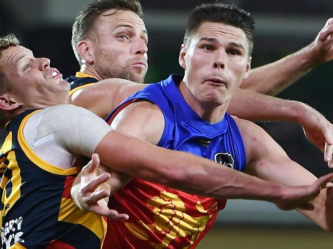 ADELAIDE, AUSTRALIA - MAY 14: Eric Hipwood of the Lions has a mark spoiled by Mitchell Hinge and Brodie Smith  of the Crows during the round nine AFL match between the Adelaide Crows and the Brisbane Lions at Adelaide Oval on May 14, 2022 in Adelaide, Australia. (Photo by Mark Brake/Getty Images)