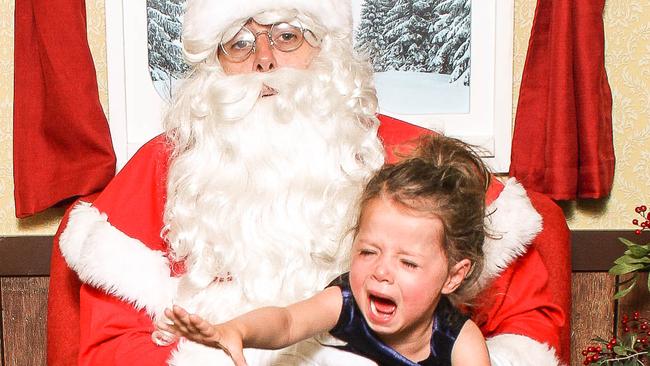 He may bring them presents, but some kids are less than impressed taking photos with Santa.