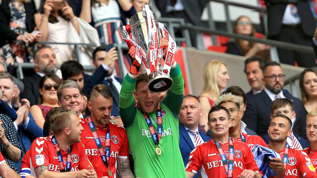 Dillon Phillips of Charlton Athletic lifts the trophy as he celebrates victory and promotion