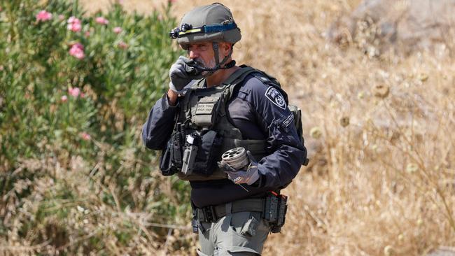 A member of Israeli security forces inspects remnants of rockets launched from southern Lebanon which fell in Kiryat Shmona, Picture: AFP