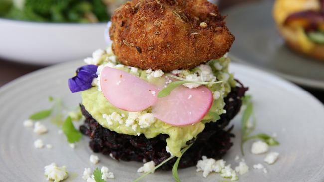 Beetroot fritters with smashed avocado, crumbed feta, crispy poached and green herb oil. Photo Martin Lange.