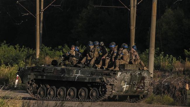 Ukrainian army's fighters sit on the top of an armed vehicle in Kharkiv. Photo: Juan BARRETO