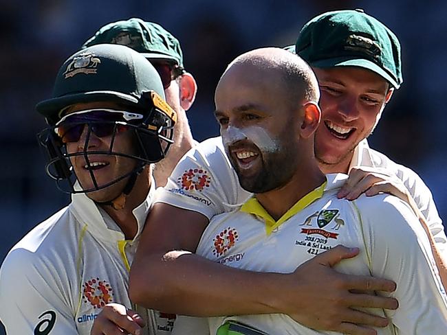 Australia's bowler Nathan Lyon (C) is congratulated by teammates after dismissing India's captain Virat Kohli during day four of the second Test cricket match between Australia and India in Perth on December 17, 2018. (Photo by WILLIAM WEST / AFP) / -- IMAGE RESTRICTED TO EDITORIAL USE - STRICTLY NO COMMERCIAL USE --