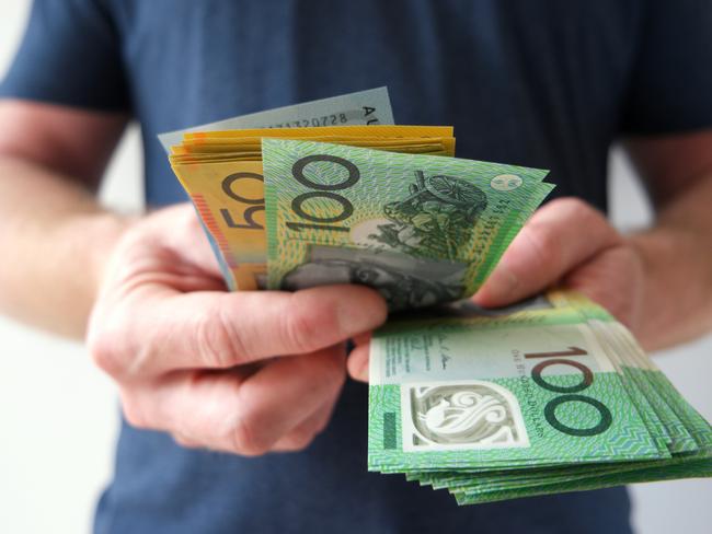 A man counting Australian dollar bills. A picture that describes buying, paying, handing out money, or showing money.